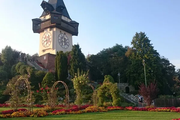 Grazer Uhrturm auf dem Schlossberg mit blühenden Gartenanlagen im Vordergrund